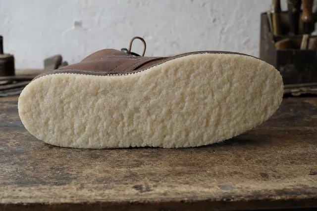 Semelle de crêpe naturelle, blanc laiteux, à la texture grumeleuse.